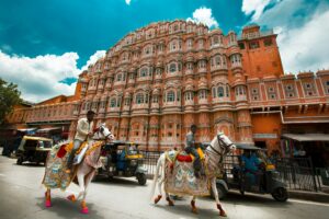 Hawa Mahal Jaipur Rajasthan India with decorated horses and riders, Pink City street view for North India travel guide